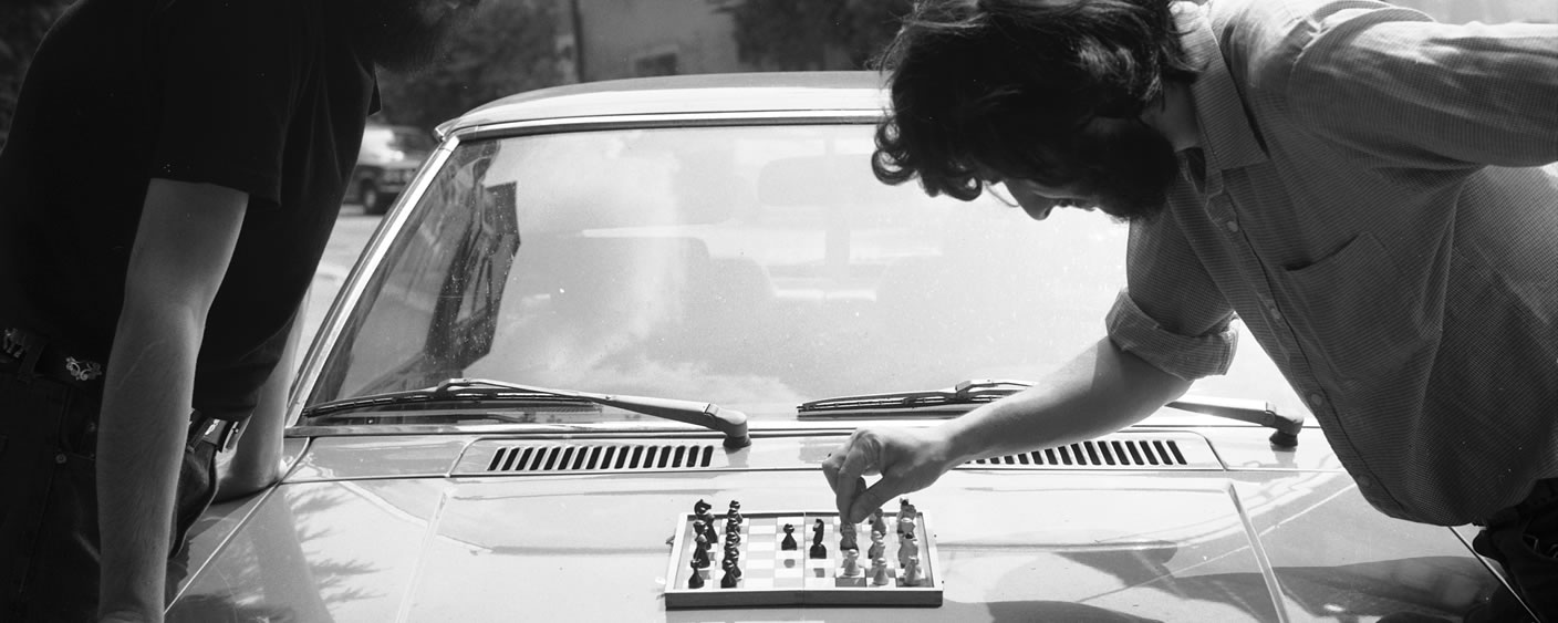 Two people are playing chess on a car