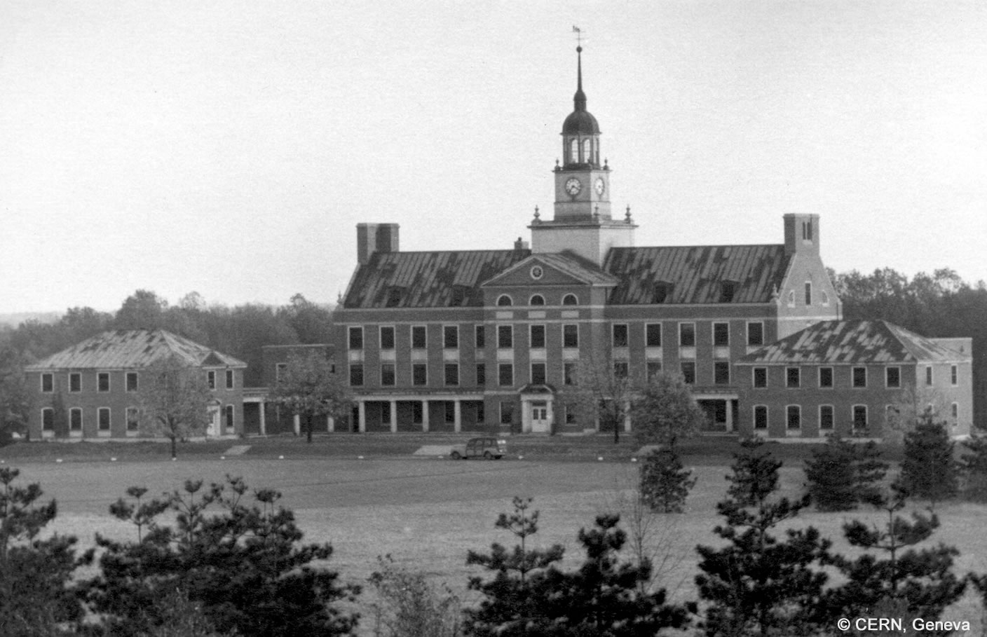 A stately building with a large meadow in front of it