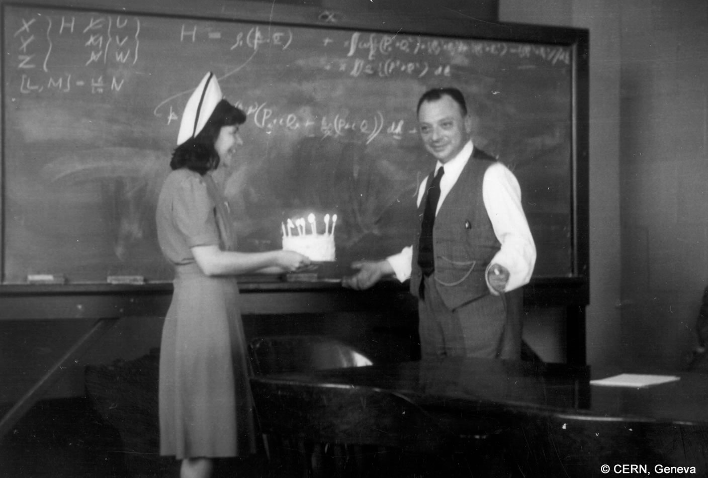 Wolfgang Pauli receives a cake for his 45th birthday from a lady