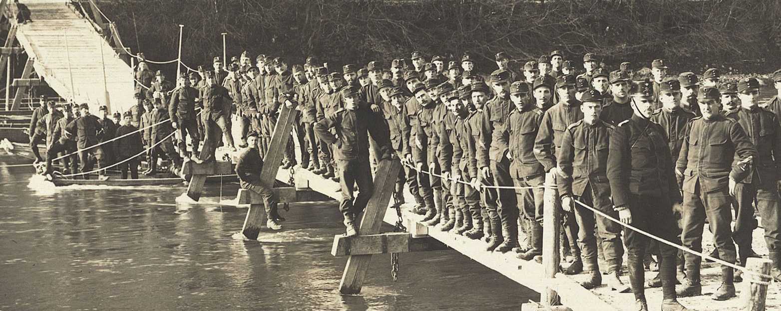 Numerous people standing on a footbridge in the water