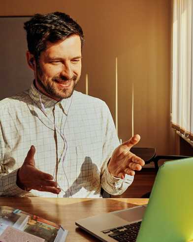 Speaking/smiling person working on a notebook