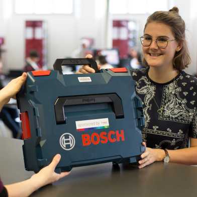 Junge Frau mit Bosch-Werkzeugkoffer